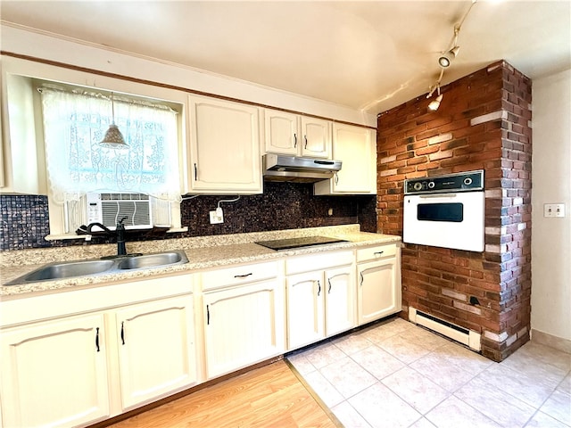 kitchen featuring white oven, backsplash, light wood-type flooring, black electric stovetop, and sink