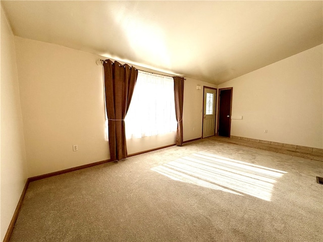 spare room with vaulted ceiling and carpet floors