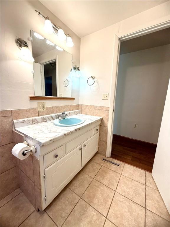226 Cottage Ave, Masontown, PA 15461 - bathroom with tile patterned flooring, vanity, and tile walls