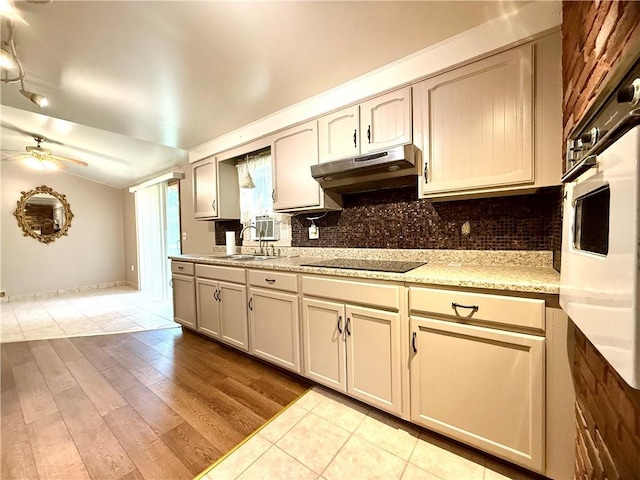 226 Cottage Ave, Masontown, PA 15461 - kitchen with under cabinet range hood, a sink, black electric stovetop, and backsplash