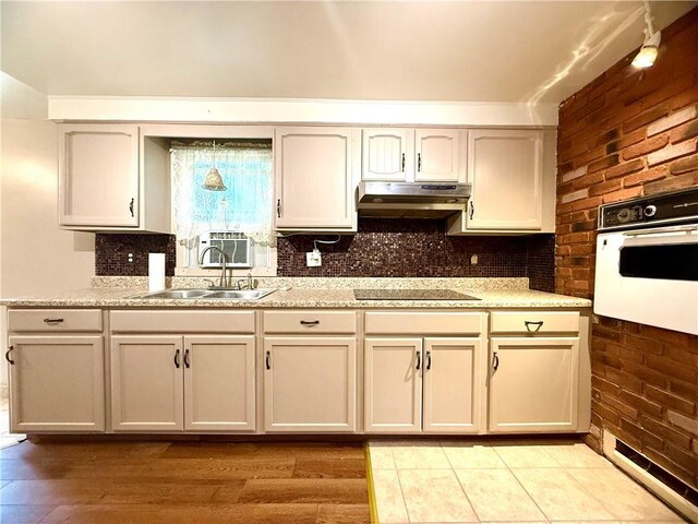 226 Cottage Ave, Masontown, PA 15461 - kitchen featuring oven, under cabinet range hood, black electric cooktop, backsplash, and a sink