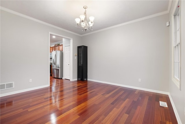 spare room with ornamental molding, a notable chandelier, and dark hardwood / wood-style floors