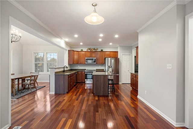 kitchen with a breakfast bar area, dark wood-type flooring, kitchen peninsula, sink, and appliances with stainless steel finishes