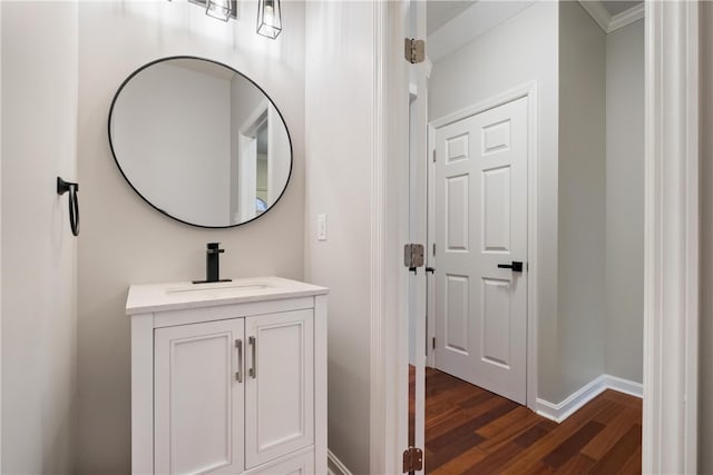 bathroom featuring vanity, ornamental molding, and wood-type flooring