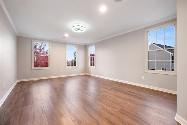 unfurnished room with ornamental molding and hardwood / wood-style floors