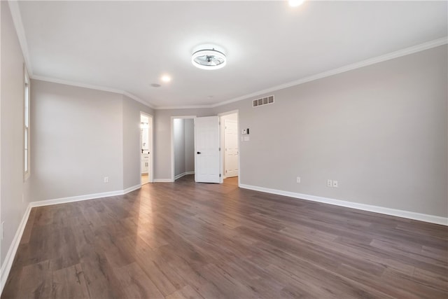 spare room with ornamental molding and dark hardwood / wood-style flooring