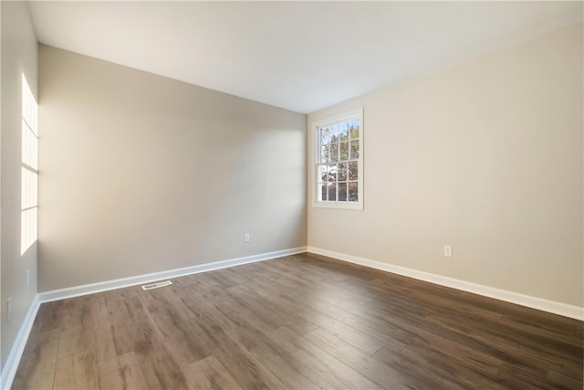 unfurnished room with dark hardwood / wood-style flooring