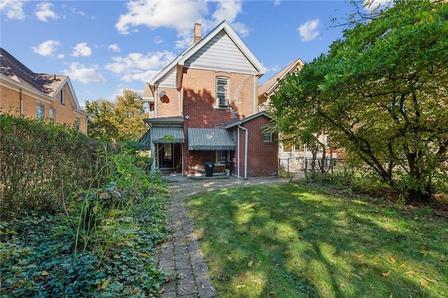 rear view of house featuring a yard