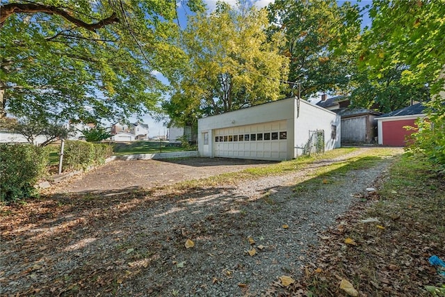 exterior space featuring a garage and an outbuilding