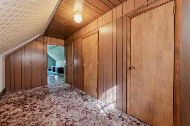 bonus room featuring lofted ceiling, wood walls, and wooden ceiling