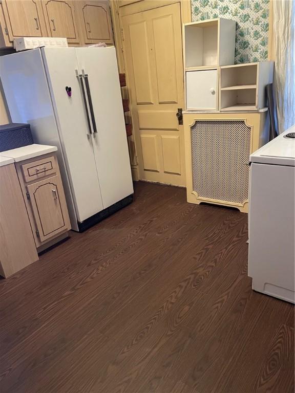 kitchen featuring dark hardwood / wood-style flooring, light brown cabinets, and white fridge