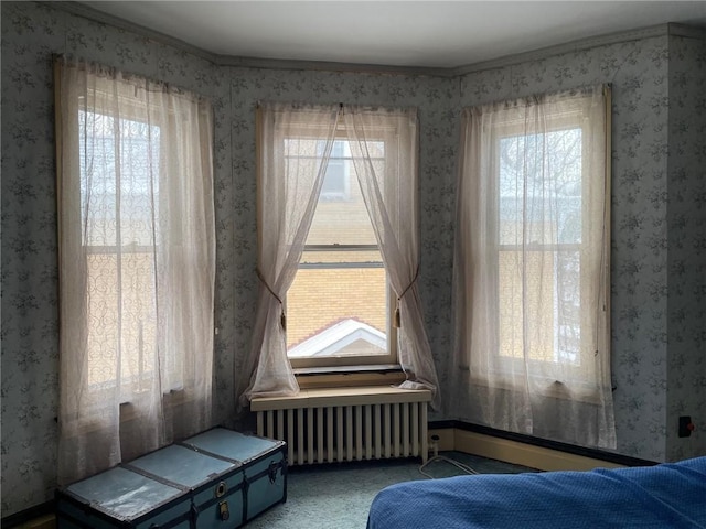 carpeted bedroom featuring ornamental molding and radiator heating unit