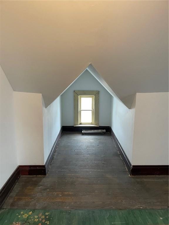 additional living space featuring vaulted ceiling and dark hardwood / wood-style flooring