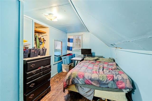 bedroom featuring a closet, wood-type flooring, and vaulted ceiling