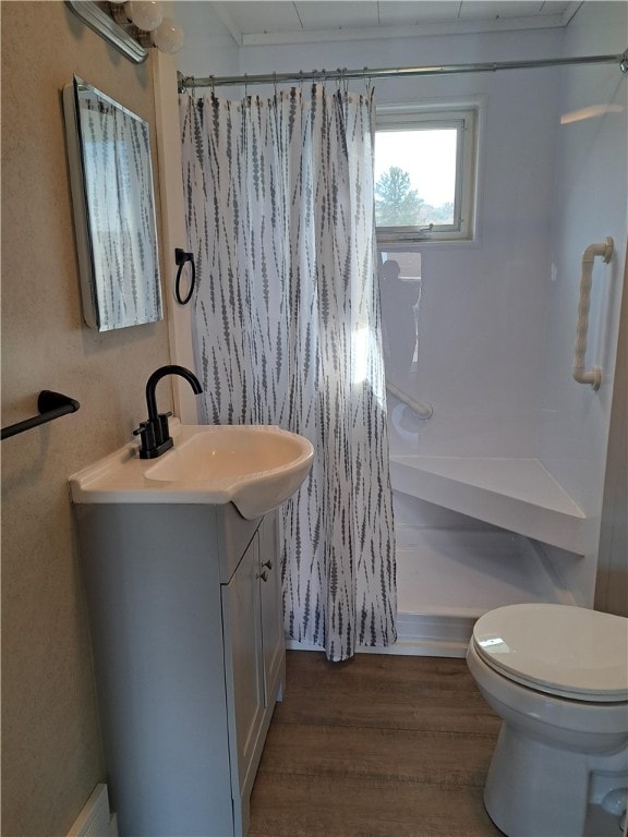 bathroom featuring hardwood / wood-style flooring, vanity, curtained shower, and toilet