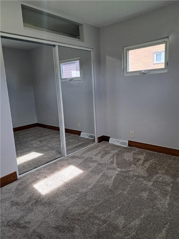 unfurnished bedroom featuring carpet and multiple windows