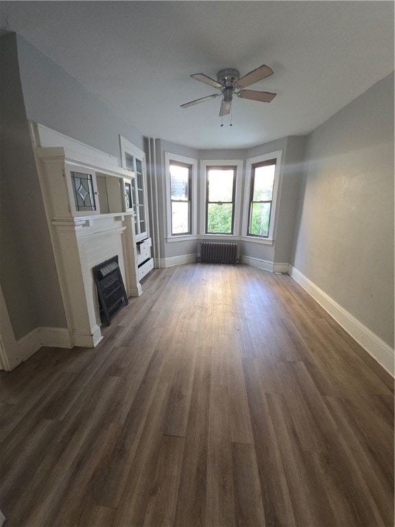 unfurnished living room with radiator, ceiling fan, and dark hardwood / wood-style flooring