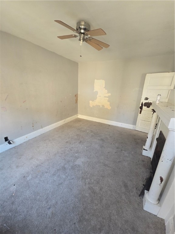 spare room featuring ceiling fan and dark colored carpet