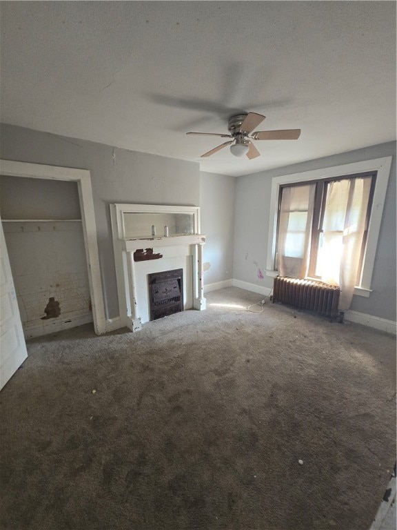 unfurnished living room featuring carpet floors, a textured ceiling, and radiator