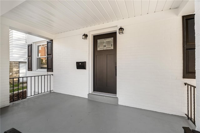 view of exterior entry featuring covered porch