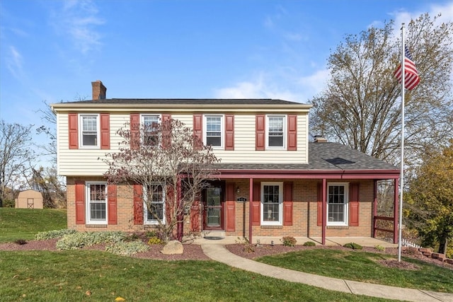 colonial-style house featuring a front lawn