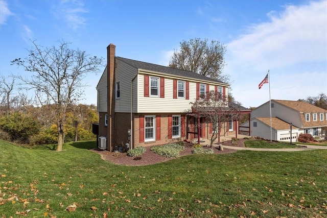 colonial home featuring a front yard and central AC unit