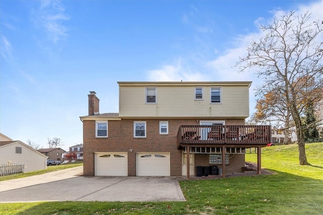 rear view of property featuring a deck, a yard, and a garage