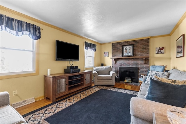 living room featuring crown molding, a brick fireplace, and hardwood / wood-style floors