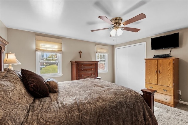 carpeted bedroom featuring a closet, ceiling fan, and multiple windows