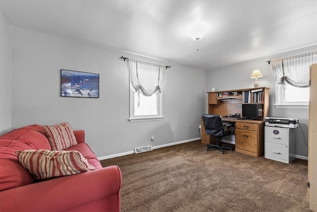 home office featuring dark carpet and a healthy amount of sunlight