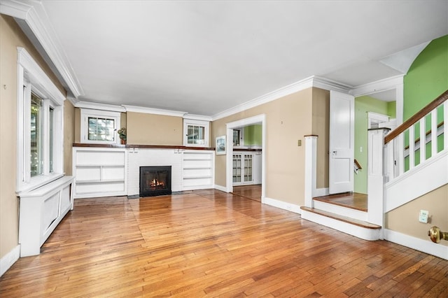 unfurnished living room featuring crown molding and light hardwood / wood-style flooring