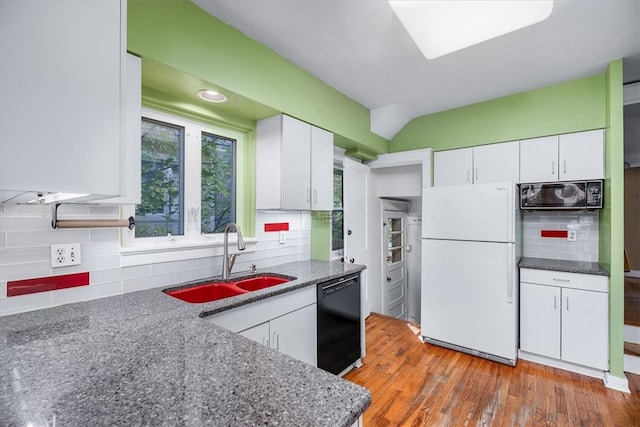 kitchen with tasteful backsplash, white cabinetry, light hardwood / wood-style flooring, black appliances, and sink