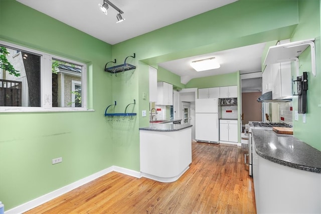 kitchen with sink, stainless steel range, white cabinets, light hardwood / wood-style flooring, and white refrigerator