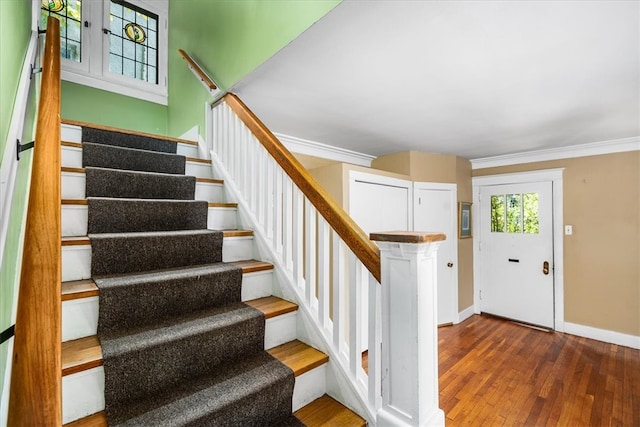 staircase featuring ornamental molding and hardwood / wood-style floors