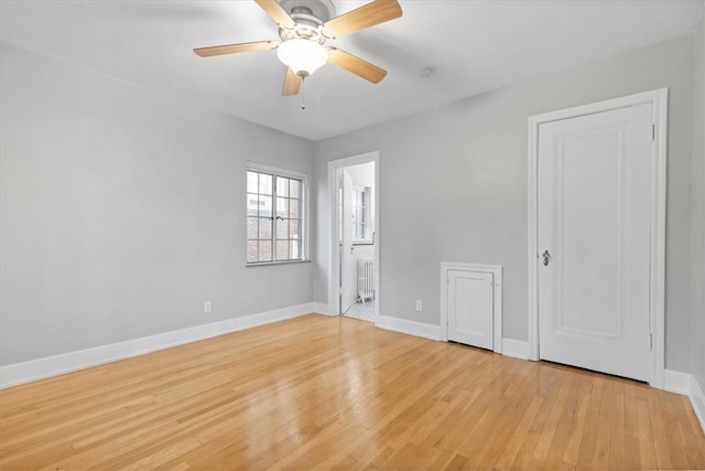 empty room featuring light hardwood / wood-style flooring, radiator, and ceiling fan