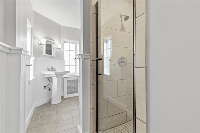 bathroom with a shower with shower door and tile patterned flooring