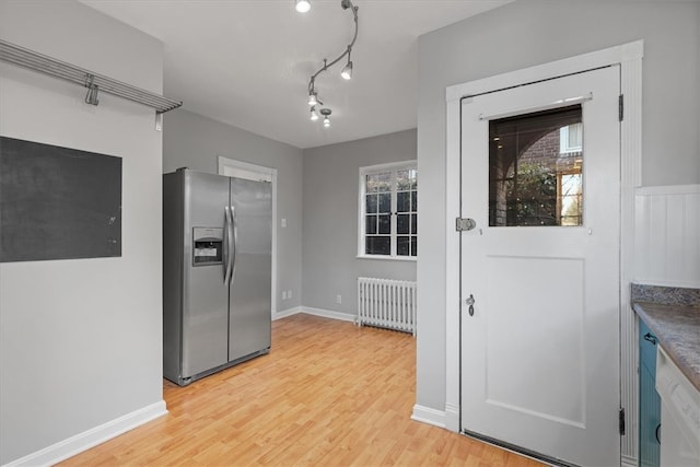 kitchen with light hardwood / wood-style floors, stainless steel fridge, radiator, and a wealth of natural light