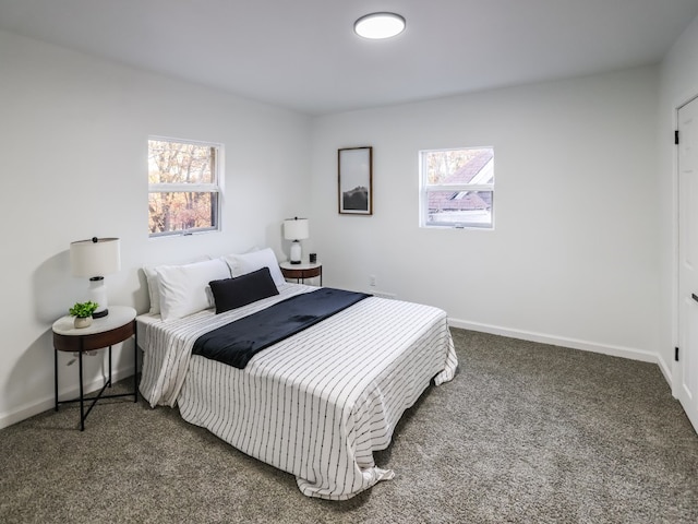 bedroom with dark colored carpet and multiple windows