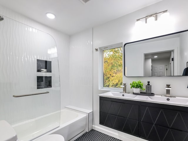 full bathroom with tile patterned floors, vanity, tiled shower / bath, and toilet