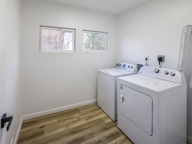 laundry area with washer and dryer and light hardwood / wood-style flooring