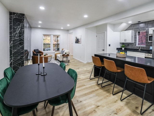 dining room with sink and light hardwood / wood-style flooring