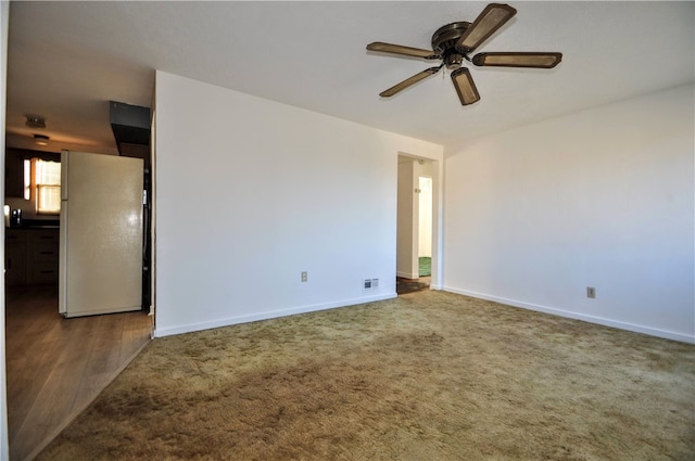 unfurnished room with ceiling fan and dark colored carpet