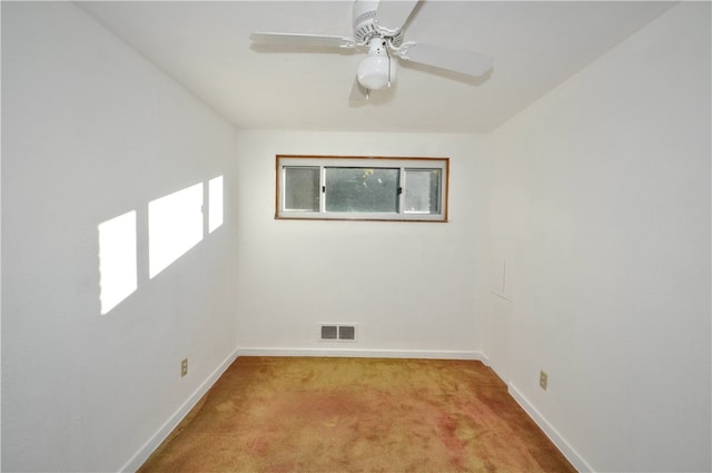 carpeted spare room featuring ceiling fan