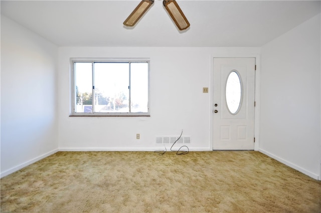 carpeted entrance foyer featuring ceiling fan