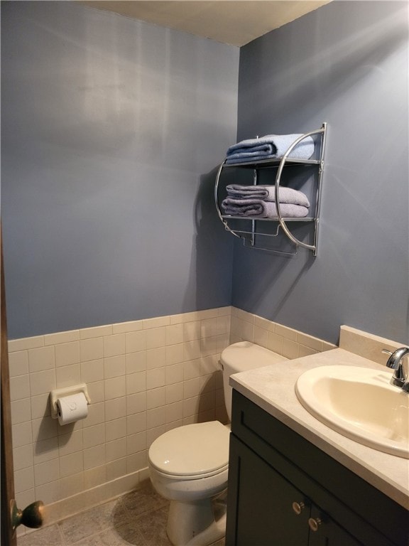 bathroom featuring tile walls, vanity, toilet, and tile patterned floors