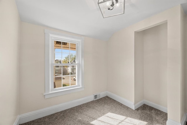 spare room featuring vaulted ceiling and carpet floors