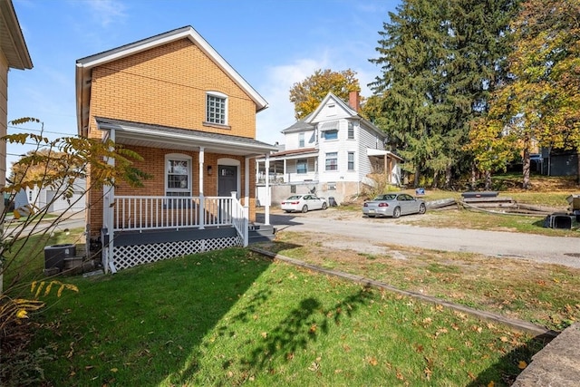 view of front of house with a front yard and covered porch