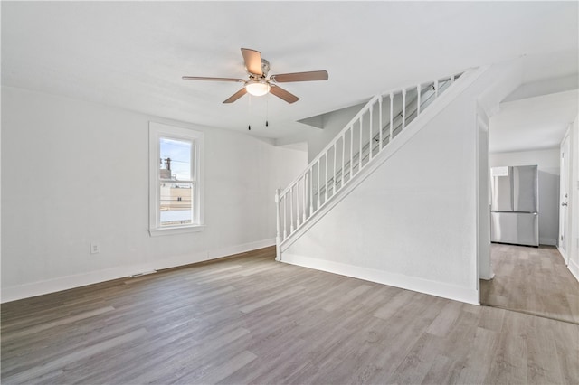 unfurnished living room featuring ceiling fan and wood-type flooring