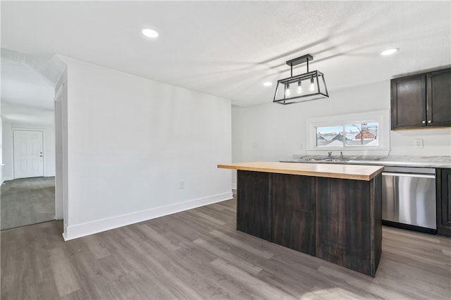 kitchen featuring dishwasher, wood counters, dark brown cabinets, a center island, and hardwood / wood-style floors