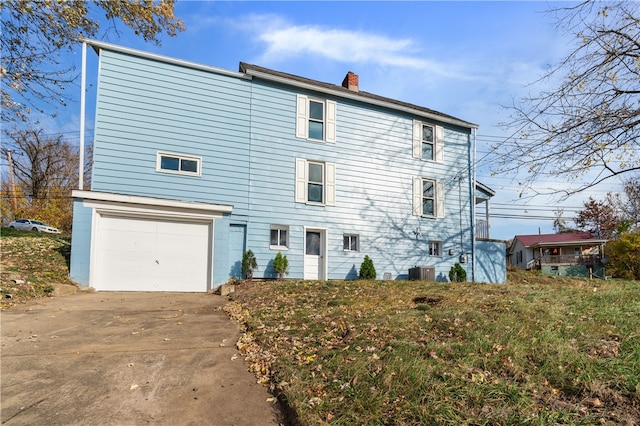 rear view of house with a garage and cooling unit